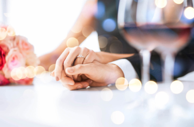 Wedding couple holding hands on table.