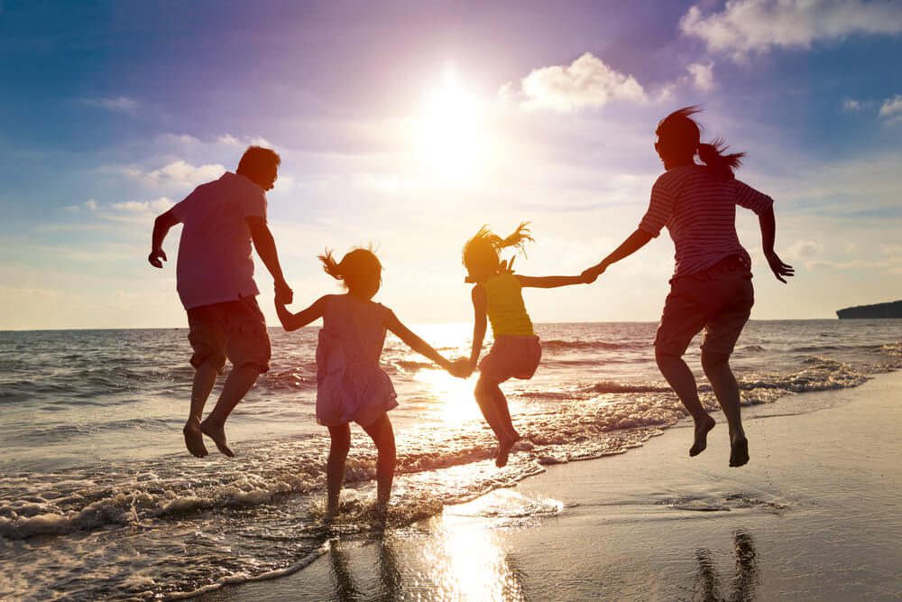 A family on the beach during their Pacific Northwest summer vacation to Oregon.