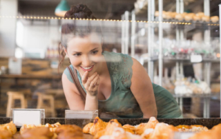 A woman looking at the case of a Newport, Oregon, bakery,