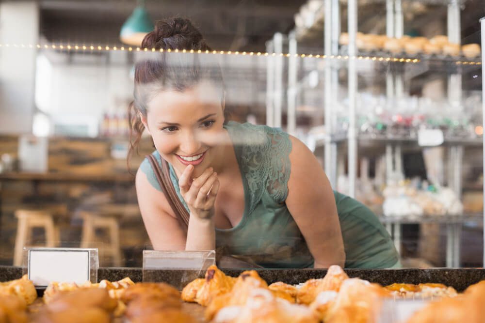 A woman looking at the case of a Newport, Oregon, bakery,