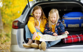 Two kids with a map before going on an Oregon Coast road trip.